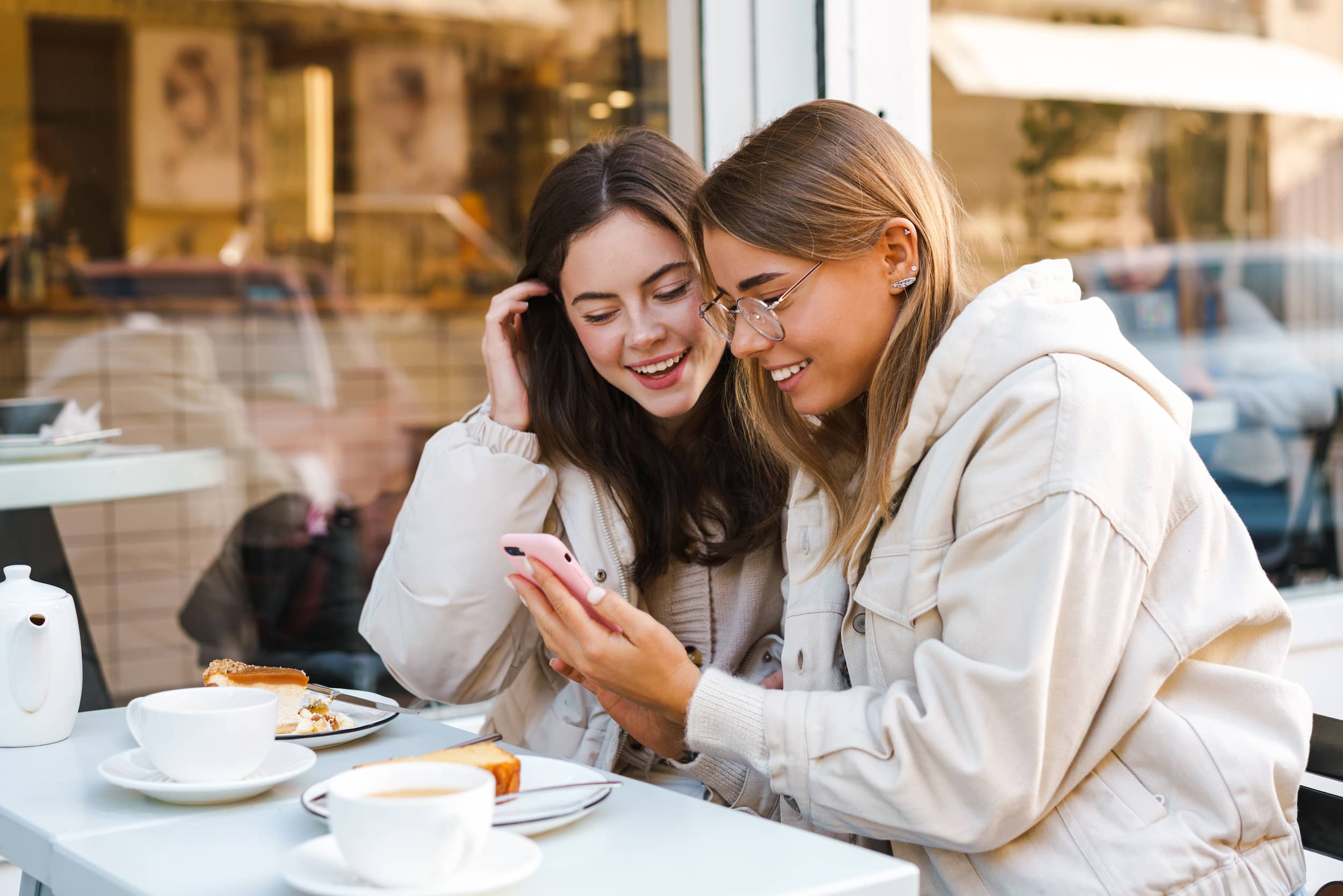 Two friends looking at a smartphone with a SaharaCase phone case.