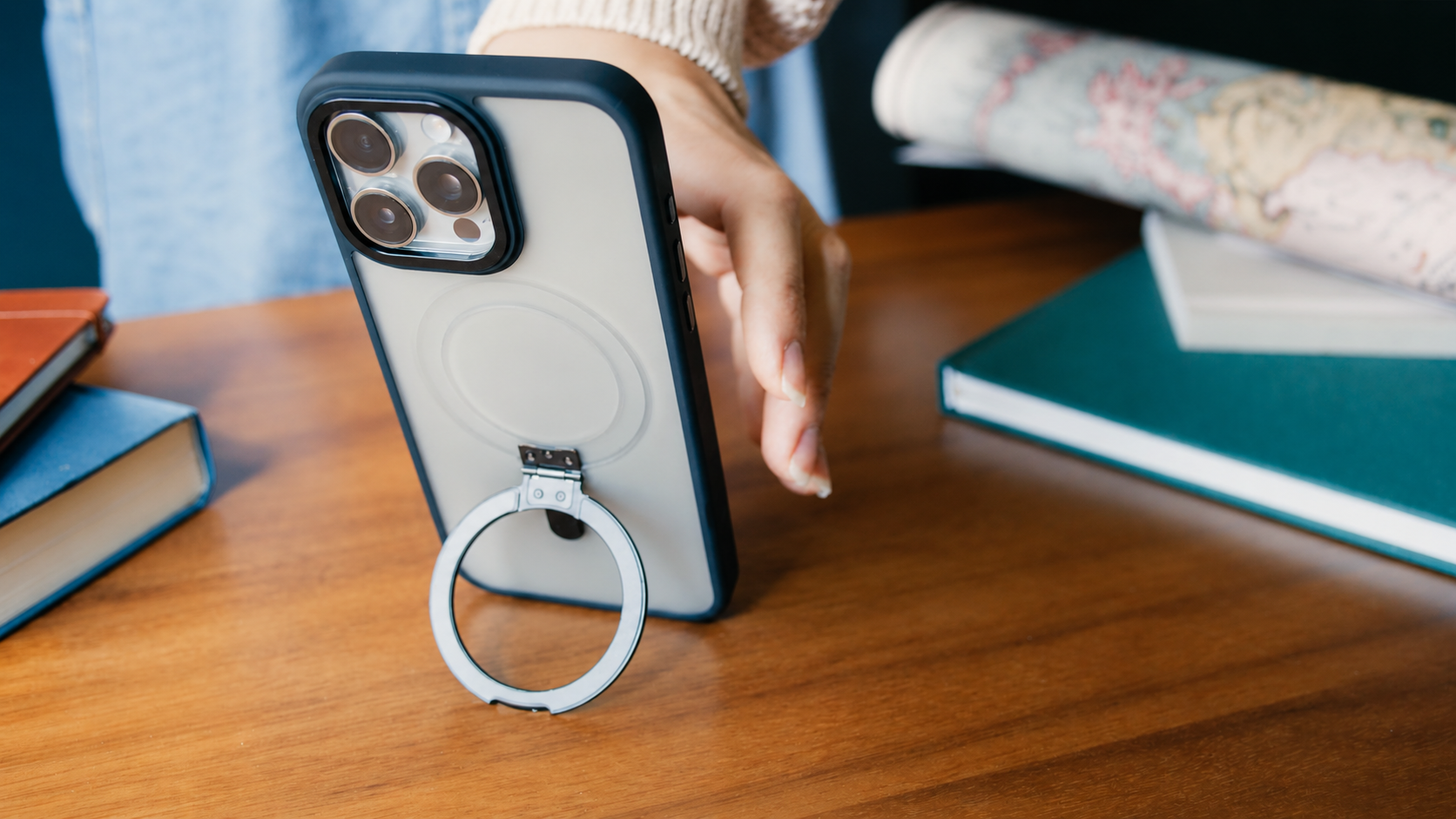 Clear-backed SaharaCase phone case with ring kickstand on a wooden desk