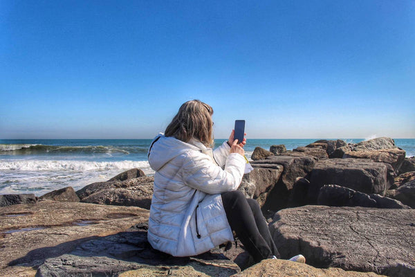 woman using Samsung Galaxy 22S Ultra next to the ocean
